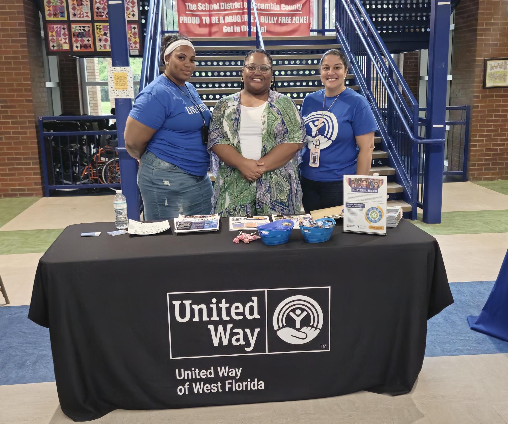 Girls standing behind a United Way Table.