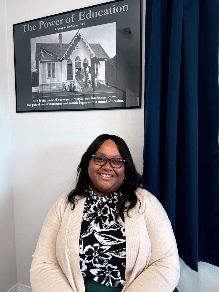 Woman sitting down smiling.