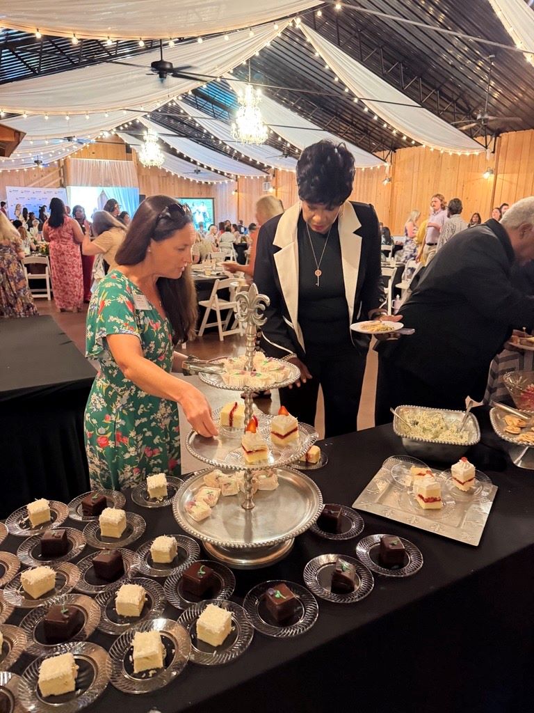 Two women choosing dessert at a table.