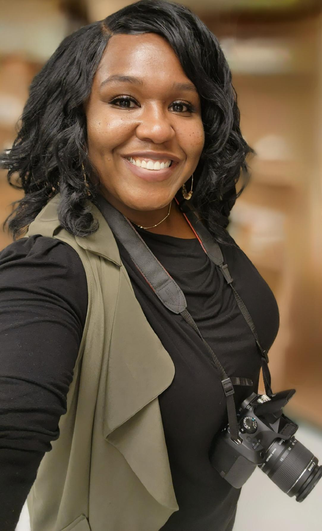Woman smiling with camera around her neck.