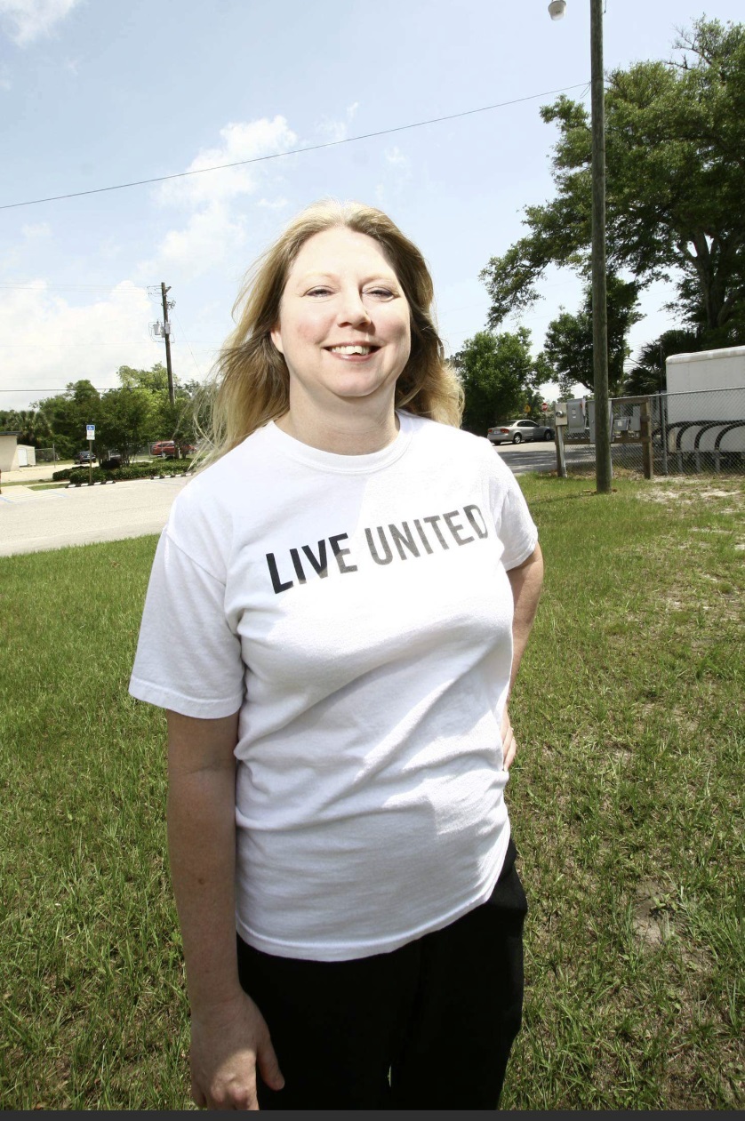Woman smiling wearing a Live United tshirt.
