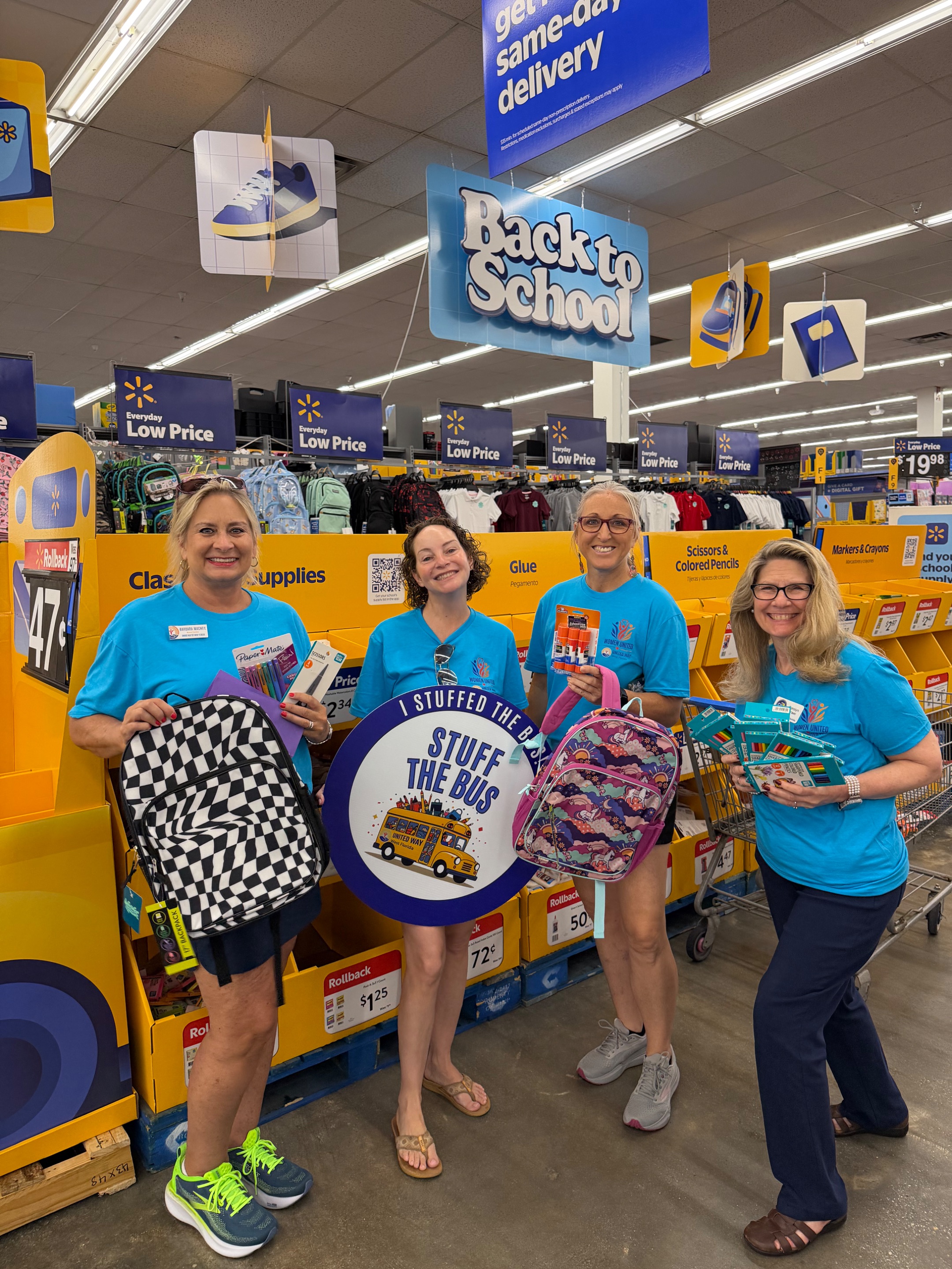 women holding school supplies, for a back to school school supply drive.