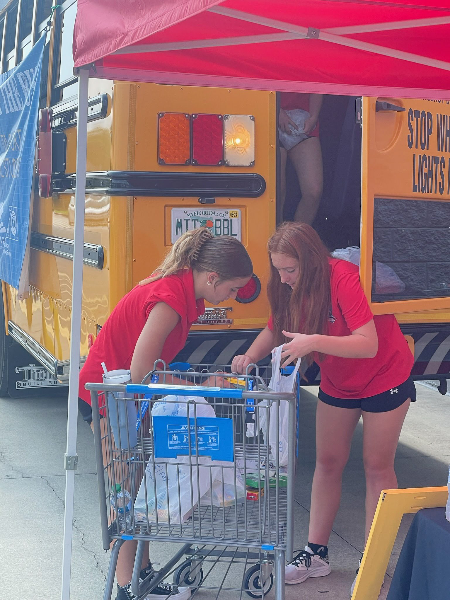 Volunteers retrieving school supplies from a cart