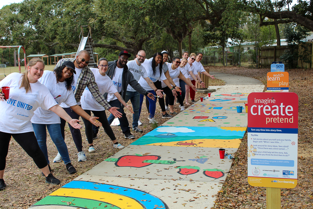 Volunteers point to painted sidewalk
