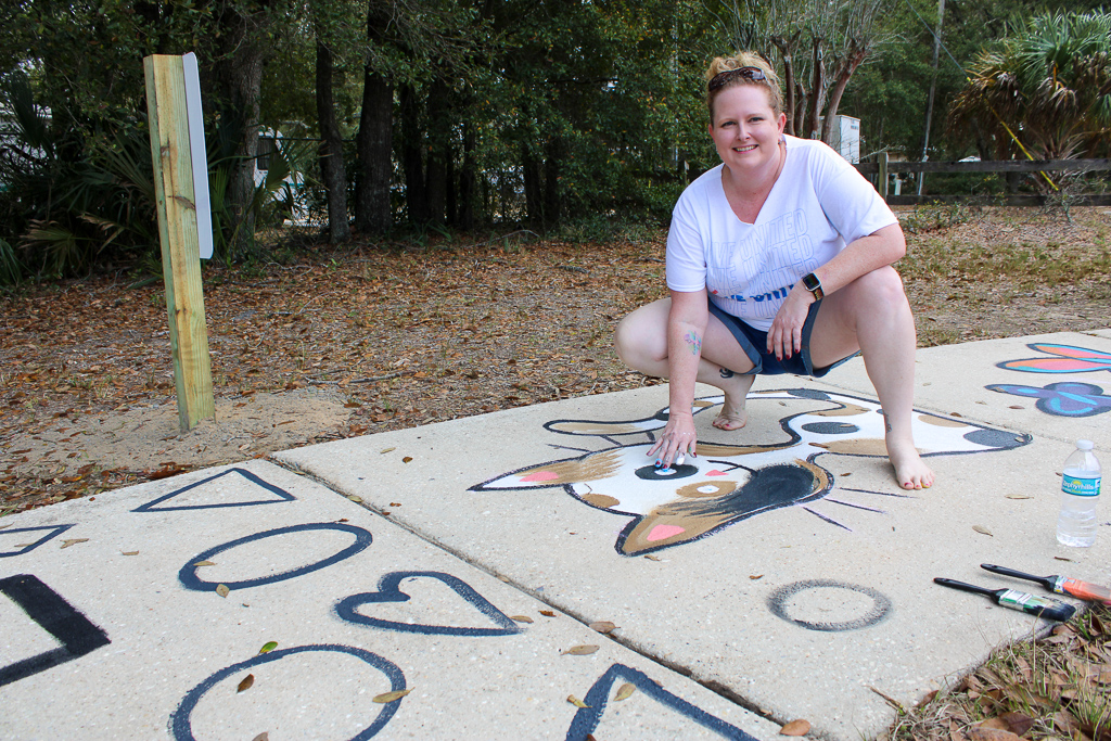 Volunteer paints sidewalk