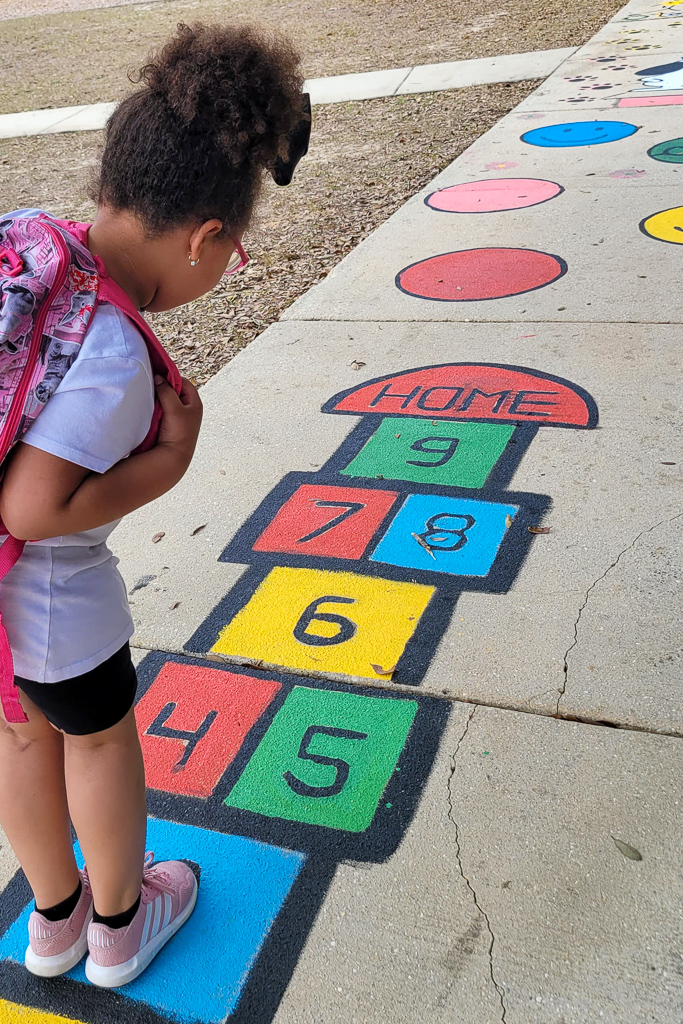 Girl looks at painted sidewalk