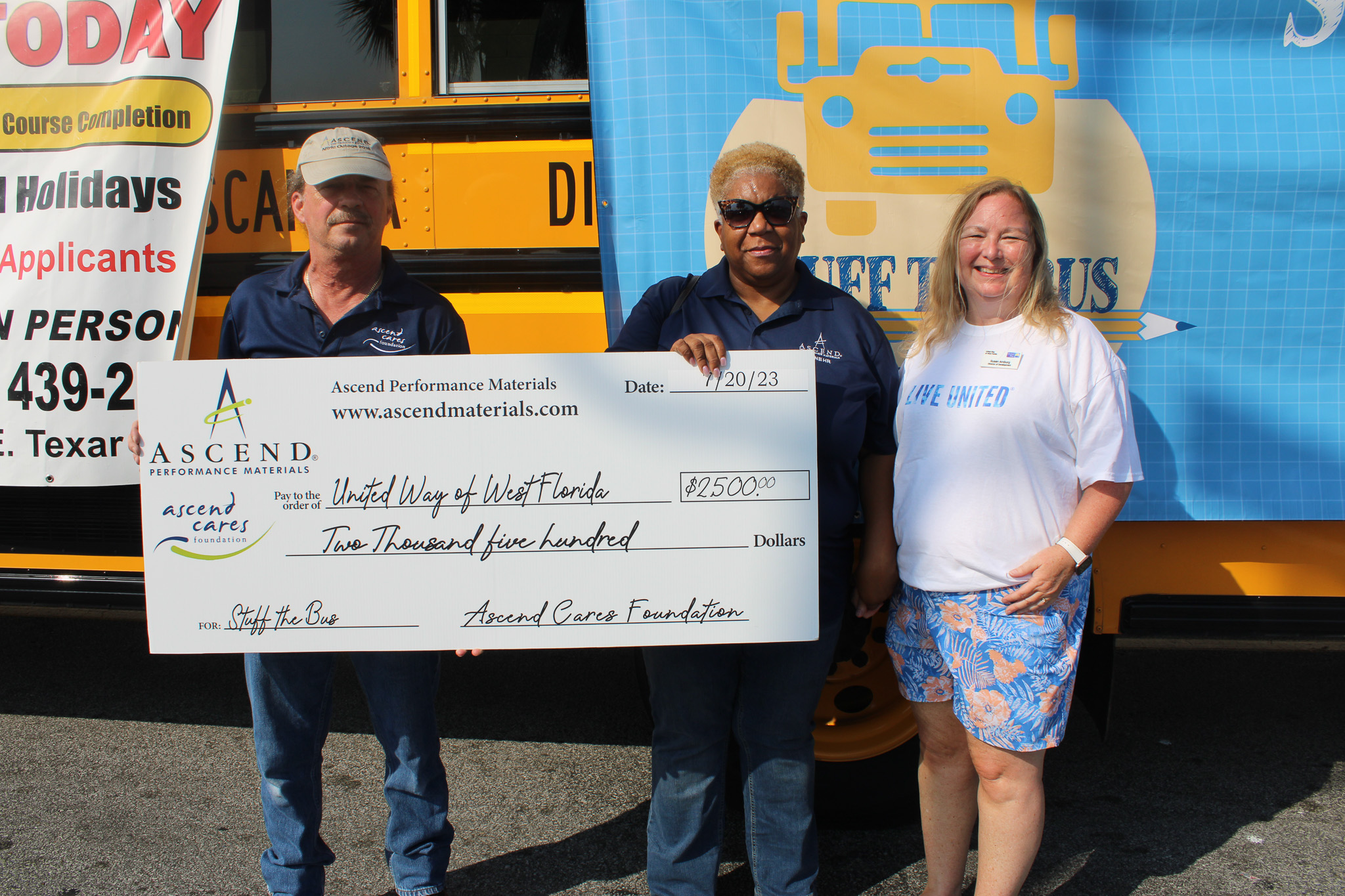 Ascend Performance Materials with $2,500 check in front of Stuff the Bus