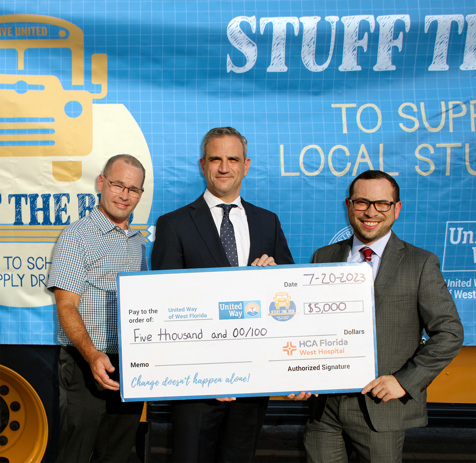 HCA Florida West Hospital Holding a $5,000 check for stuff the bus with Board Chair Todd Phillips