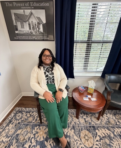 Woman sitting in a chair smiling.