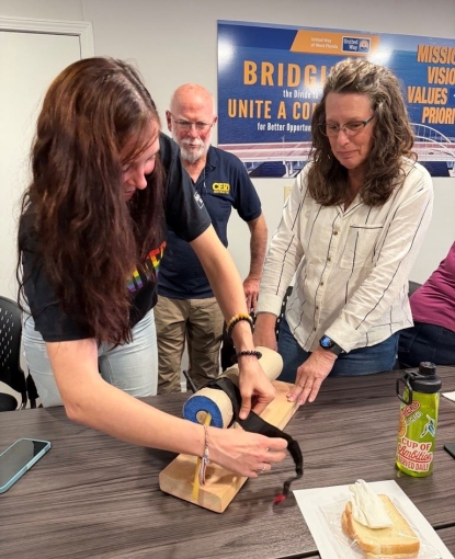 Two women putting on a tourniquet.