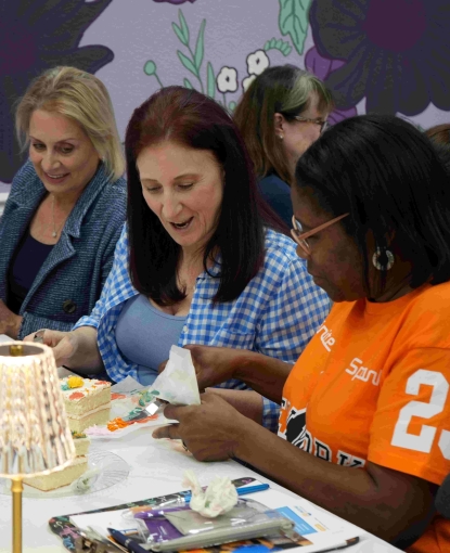Women painting a cake.