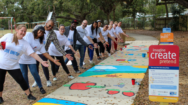 Volunteers point to painted sidewalk